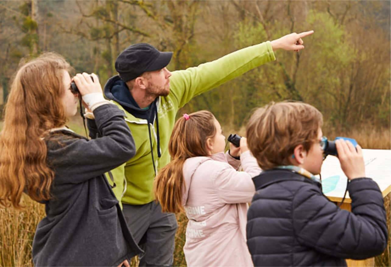 Enfant avec des jumelles observant la nature